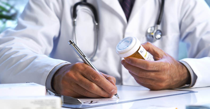 a doctor writing on a prescription pad