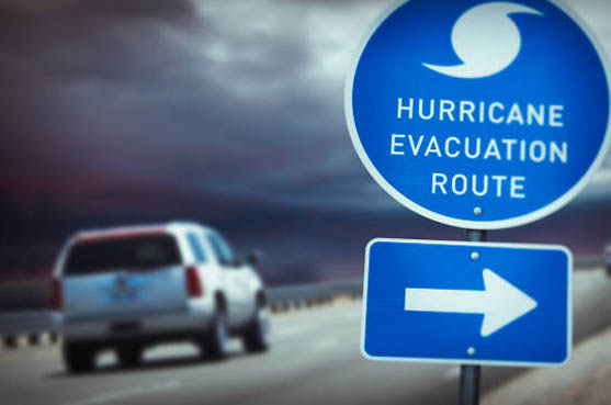 a truck driving on a road with a hurricane evacuation route sign posted